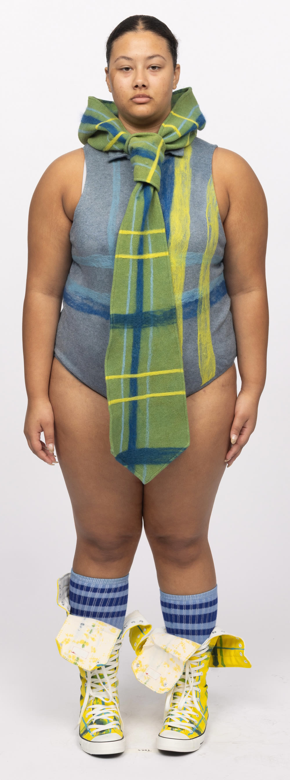 Editorial photograph — model in a blue plaid romper