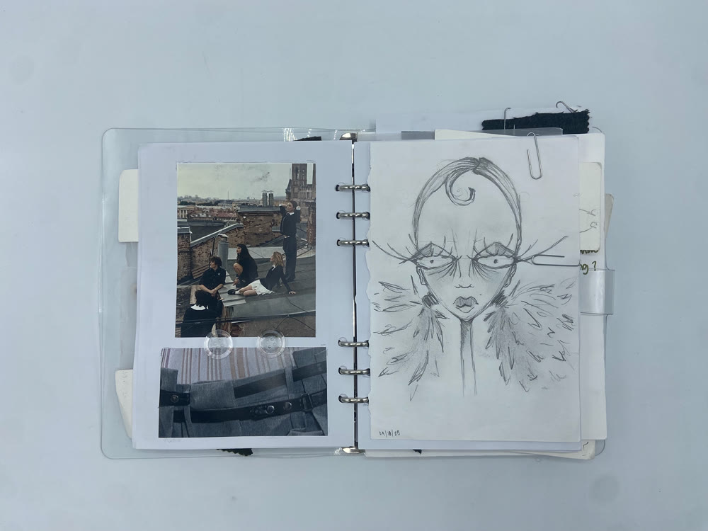 Open sketchbook with reference photos and a pencil character drawing